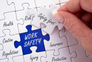 Układanie puzzli z napisem work safety – znaczenie ubezpieczenia OC zarządcy dla bezpieczeństwa właściciela mieszkania.