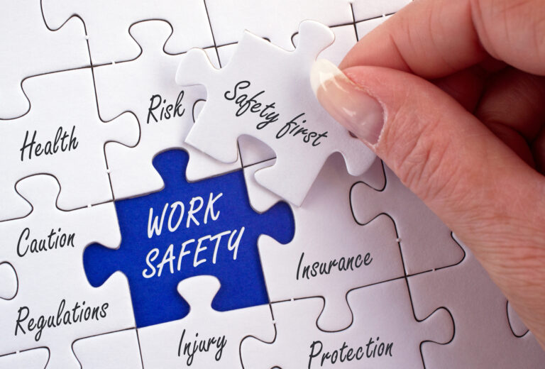 Układanie puzzli z napisem work safety – znaczenie ubezpieczenia OC zarządcy dla bezpieczeństwa właściciela mieszkania.