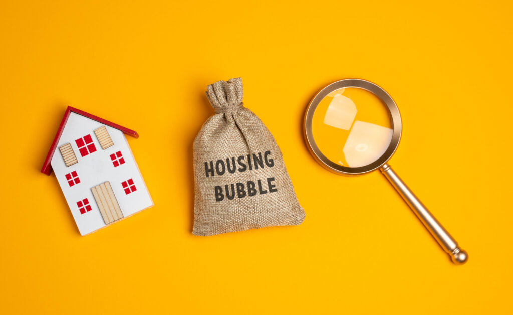 Dom, lupa i worek „housing bubble” – zawyżona cena zakupu nieruchomości i ryzyko bańki.